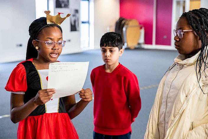 A pupil practices reading her composition aloud